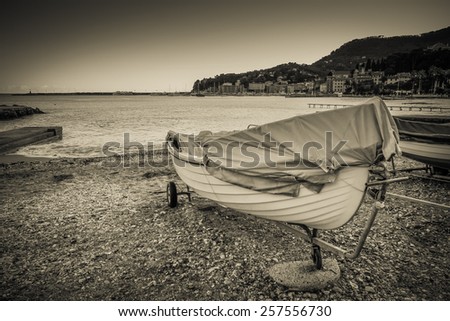 Boat docked on a beach, black and white vintage style photo.
