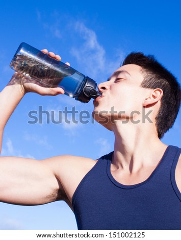 Male athlete drinking water after workout
