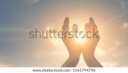 Woman hands holding the sun at dawn. Freedom and spirituality concept.  Сток-фото © 