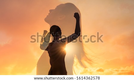 Strong woman, winning, success , and life goals concept. Young woman with arms flexed looking up to the sky. Foto d'archivio © 