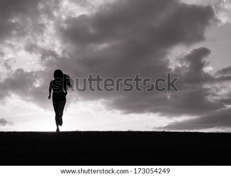 Silhouette of young woman running
