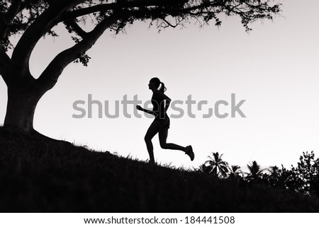 Silhouette of young woman running.