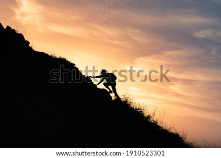 Young man climbing up to top of mountain. Self improvement and motivational goals concept.  商業照片 © 