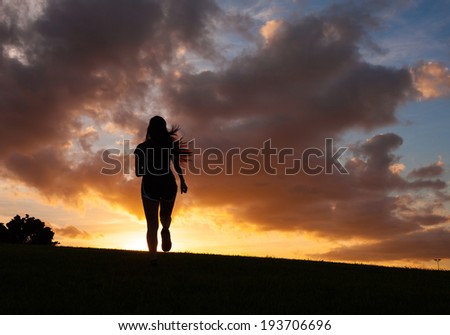 Silhouette of woman running during the sunset.