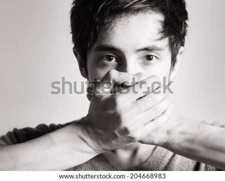 Speak no evil concept - Face of men covering his mouth.