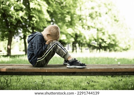 Similar – Image, Stock Photo Portrait of a sad, crouching man in a black hoodie