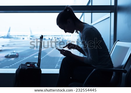 Woman using cellphone mobile in the airport