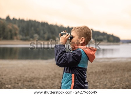 Foto Bild Junge blickt mit skeptischem Blick durch kleine Brille