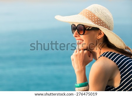 Beautiful natural portrait of woman smiling with blue water background.