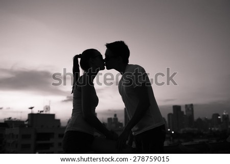 Young romantic couple kissing at night.