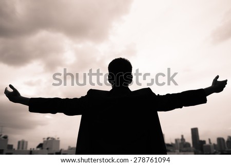 Man in the city holding his arms up. Success and freedom concept.