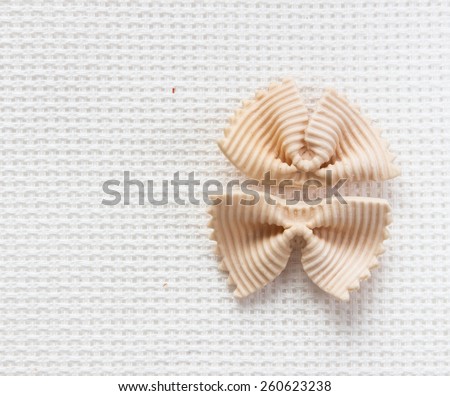 Italian bows farfalle pasta with salmon from durum wheat on a white background, top view