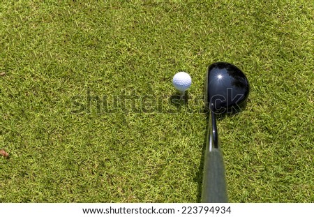 Top view of golf driver and ball on tee