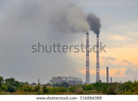 smokestack polluting the environment in Donetsk Ukraine. gray smoke on sunset background and the cloudy sky. horizontal image.