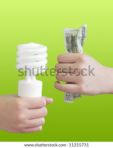 Hand holding electric light bulb and money on other hand for energy efficiency concept