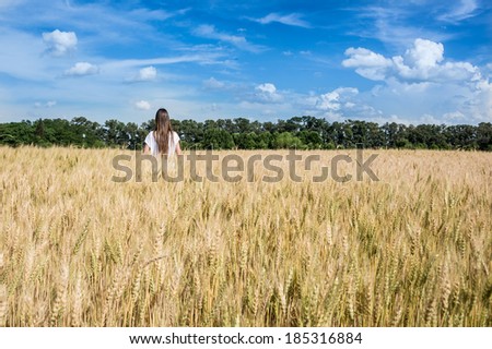 Young women walking through a Golden weed  field. Argentina countryside. South America.