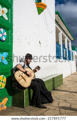 SAN JUAN CHAMULA, MEXICO - December 14, 2014: Male Playing Mexican Bass besides the San Juan Chamula Church entrance.