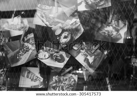 MELBOURNE, AUSTRALIA, 11 August 2015. Pictures of food in Window of Restaurant With Reflection of Street Black & White.