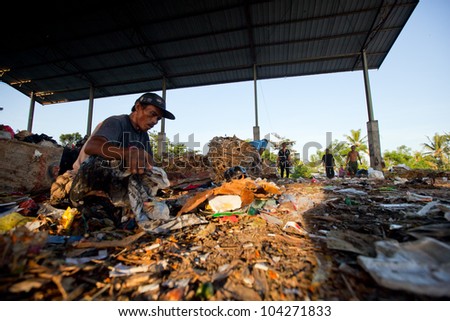 BALI, INDONESIA - APRIL 11: People from Java island working in a scavenging at the dump on April 11, 2012 on Bali, Indonesia. Bali daily produced 10,000 cubic meters of waste.