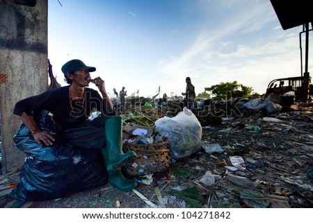 BALI, INDONESIA - APRIL 11: People from Java island working in a scavenging at the dump on April 11, 2012 on Bali, Indonesia. Bali daily produced 10,000 cubic meters of waste.