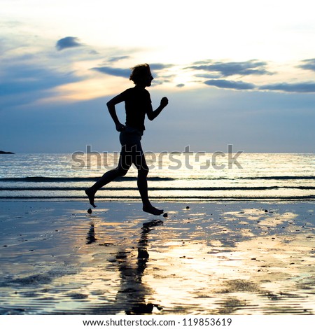 Female runner silhouette with a soft pastel sunset sky as backdrop (backlit)