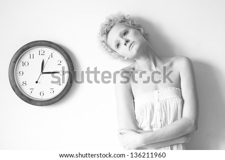 Conceptual portrait of girl with big clock, black and white photo.
