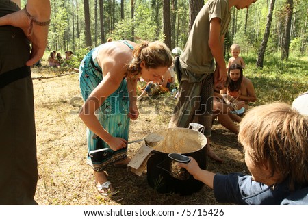 PSKOV REGION, RUSSIA - JULY 19: Members of the Russian Rainbow Family (Youth counterculture 1960\'s: bohemianism, hipster and hippie culture) prepare a meal during an annual gathering near Lake Asho on July 19, 2010 in Pskov Region, Russia.
