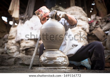 BHAKTAOUR, NEPAL - DEC 7, 2013: Unidentified Nepalese man working in his pottery workshop, Dec 7, 2013 in Bhaktapur, Nepal. 100 cultural groups have created an image of Bhaktapur as Capital of Nepal Arts.