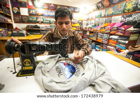 KATHMANDU, NEPAL - DEC 20: Unidentified Nepali man does embroidery on clothes in a small workshop, Dec 20, 2013 in KTM, Nepal. Nepal is one of poorest countries of world, unemployment rate of 46 %.