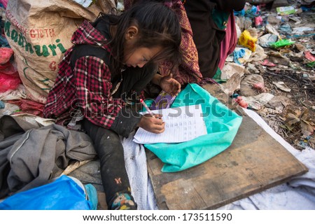 KATHMANDU, NEPAL - DEC 19: Unidentified child is sitting while her parents are working on dump, Dec 19, 2013 in Kathmandu, Nepal. In Nepal annually die 50,000 children, in 60% of cases -malnutrition.