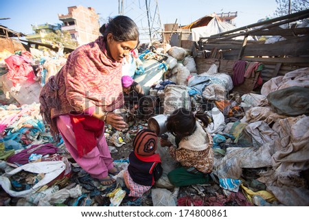 KATHMANDU, NEPAL - DEC 24, 2013: Unidentified child and his parents during lunch in break between working on dump. Only 35% of population Nepal have access to adequate sanitation