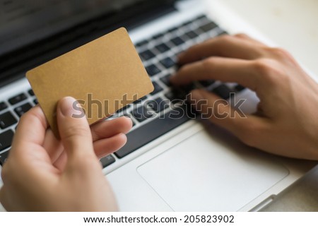 Discount card in a female hand, during shopping through Internet (banner for your message)