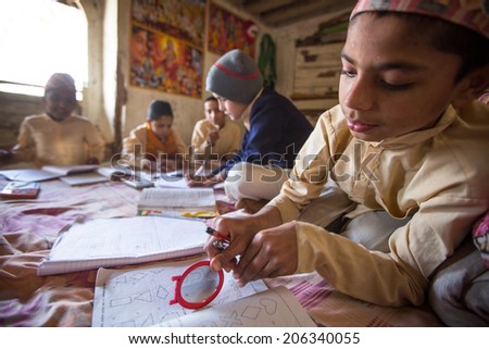 KATHMANDU, NEPAL - DEC 9, 2013: Unknown children doing homework at Jagadguru School. School established at 2013, to let new generation learn Sanskrit and preserve Hindu culture.