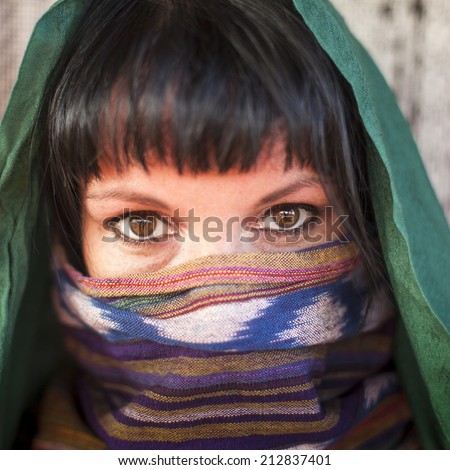 Close-up portrait of young girl covers her face with a veil. Hijab.