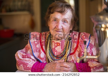 Elderly grandmother in ethnic clothes sitting in his house.