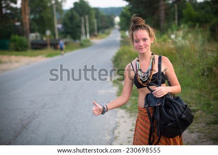 Young cute girl stops the car near the road. Hitchhiking.