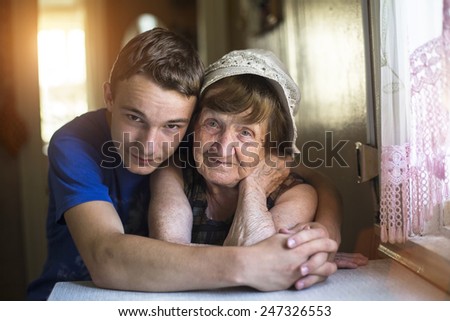 Grandson hugging her grandmother posing for a portrait.