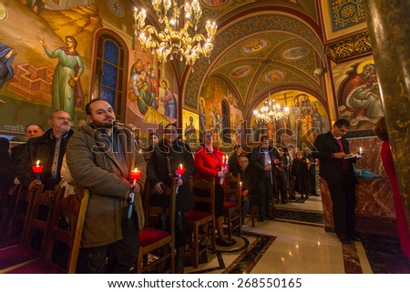 ATHENS, GREECE - APR 12, 2015: Unknown people during celebration of Orthodox Easter (Midnight Office of Pascha) Holy Saturday is often the only time that the Midnight Office will be read in parishes.