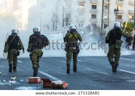 ATHENS, GREECE - APR 16, 2015: Riot police with their shield, take cover during a rally in front of the Athens University, which is under occupation by protesters leftist and anarchist groups.