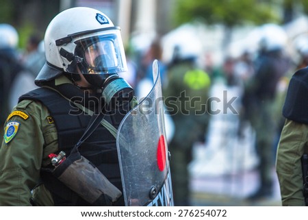 ATHENS, GREECE - CIRCA APR, 2015: Riot police with their shield, take cover during a rally in front of Athens University, which is under occupation by protesters leftist and anarchist groups.