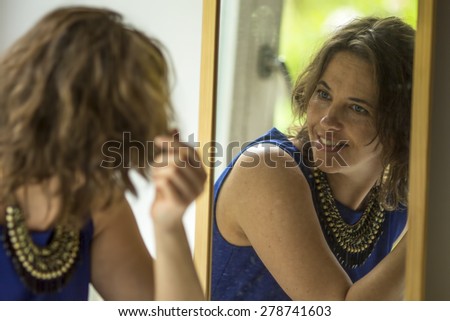 Young woman looks in the mirror.