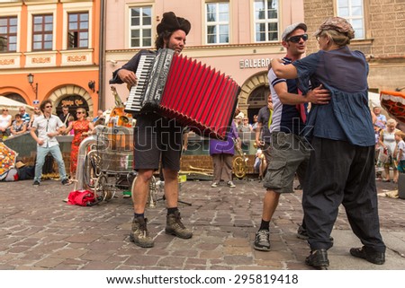 KRAKOW, POLAND - JUL 12, 2015: Participants at the annually (July 9-12) 28th International Festival of Street Theatres - Orchestre International du Vetex (Belgium/France) in the Main Square of Krakow.