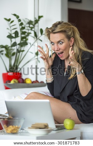 Young business woman looking at a laptop in a state of shock. Stress, fear, shock.