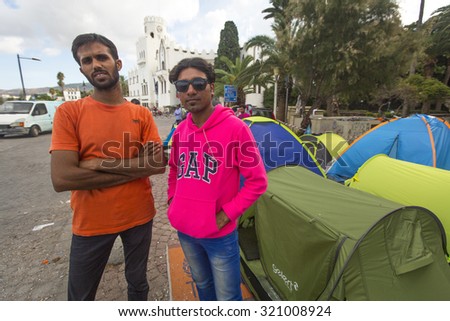 KOS, GREECE - SEP 27, 2015: Unidentified war refugees near tents. More than half are migrants from Syria, but there are refugees from other countries -Afghanistan, Pakistan, Iraq, Iran, Mali, Somalia.