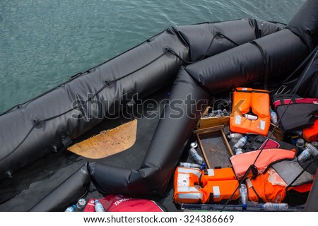 KOS, GREECE - SEP 28, 2015: Life Jackets discarded and sunken Turkish boat in the port. Kos island is located just 4 kilometers from the Turkish coast, and many refugees come from Turkey in boats.