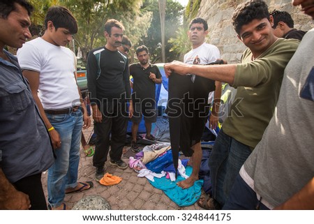KOS, GREECE - SEP 28, 2015: War refugees receive humanitarian assistance. More than half are migrants from Syria, but there are refugees from other countries-Afghanistan, Pakistan, Iraq, Iran.
