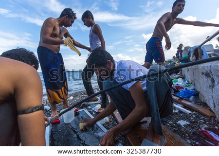 KOS, GREECE - SENT 28, 2015: Unidentified refugees wash clothes on the beach. Kos island is located just 4 kilometers from the Turkish coast, and many refugees come from Turkey in an inflatable boats.