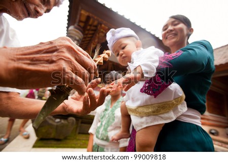 BALI, INDONESIA - MARCH 28: Unidentified child during the ceremonies of Oton - is the first ceremony for baby\'s on which the infant is allowed to touch the ground on March 28, 2012 on Bali, Indonesia.