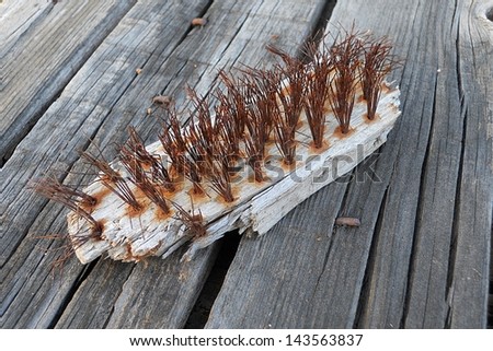 Old rusty wire brush on weathered wooden surface