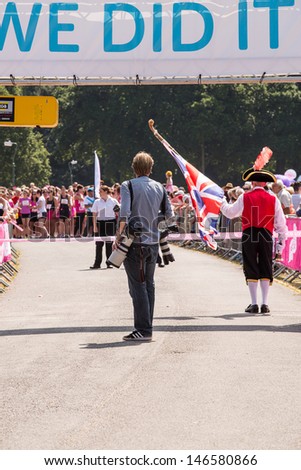 SOUTHAMPTON, UK - JULY 14: Press photographer and Town Crier at the start of the annual Race for Life, where women run to raise money for Cancer Research. 14 July 2013
